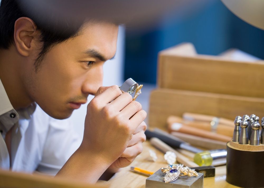 male jeweler examining a diamond with loupe